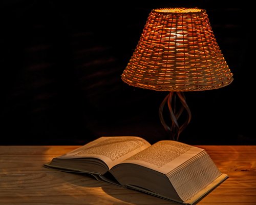 Person turning off a bedside lamp